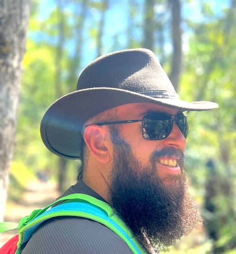 Morgan Lyddon smiling on a wooded trail